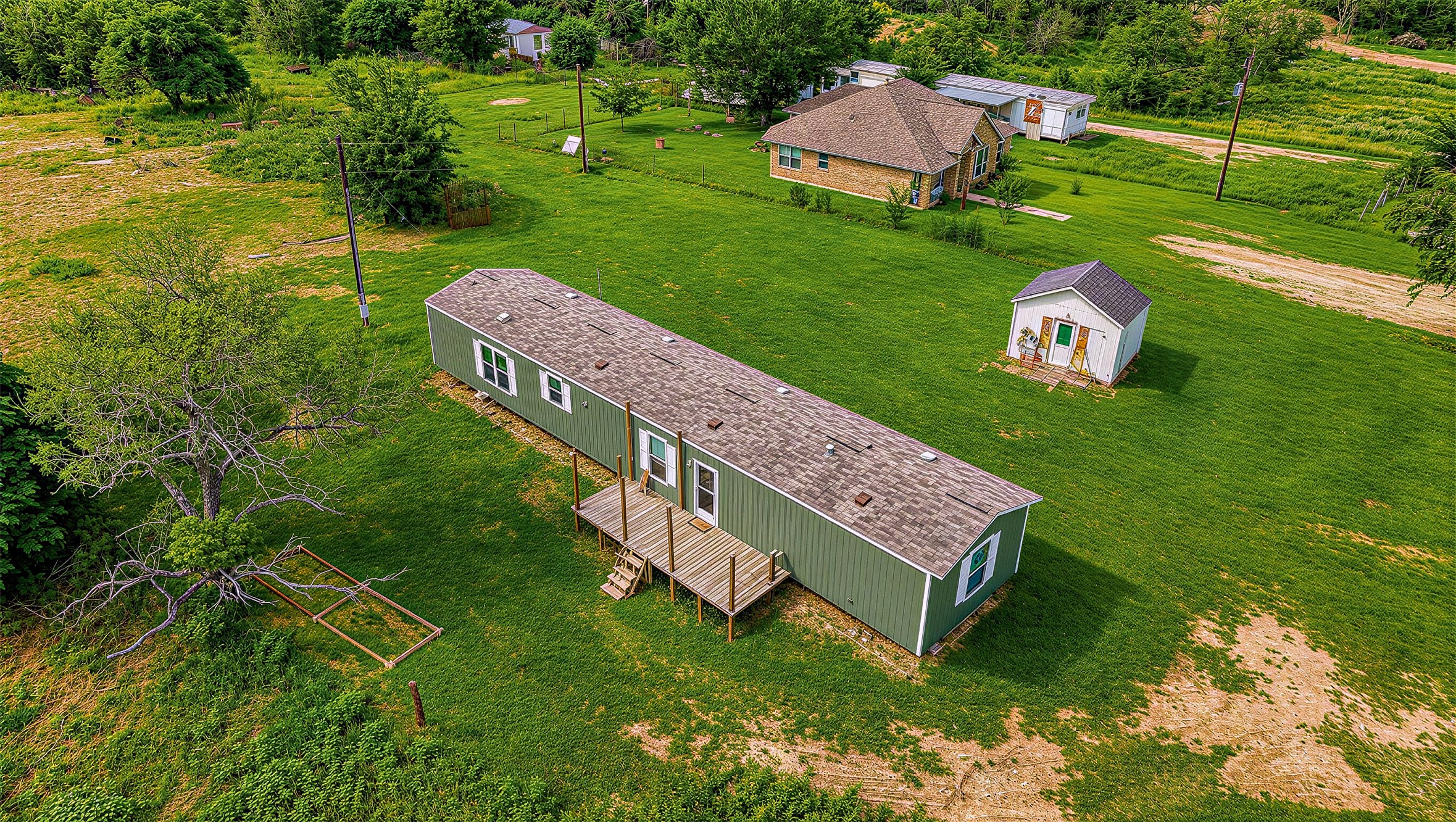 935 Lower Red Rock Road Bastrop, TX 78602 - Photo 23 of 25 Aerial view of sprawling grounds encompass this serene property featuring multiple structures and ample space.