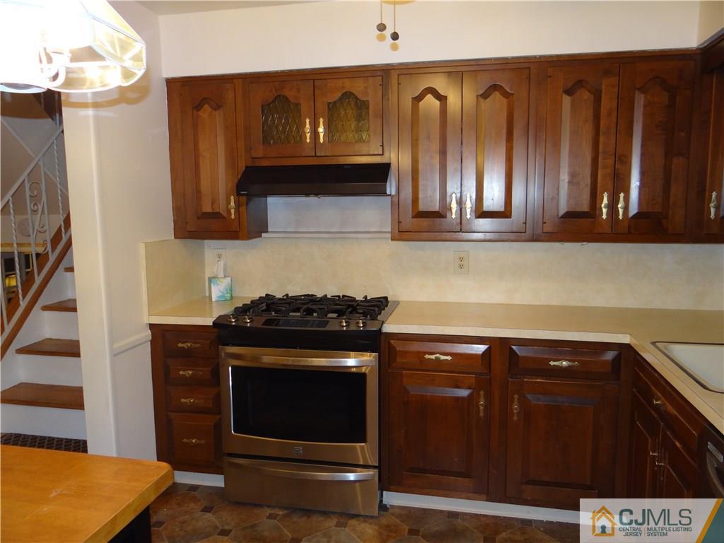 9 Hill Road Edison, NJ 08817 - Photo 8 of 16 a kitchen with wooden cabinets and a stove top oven