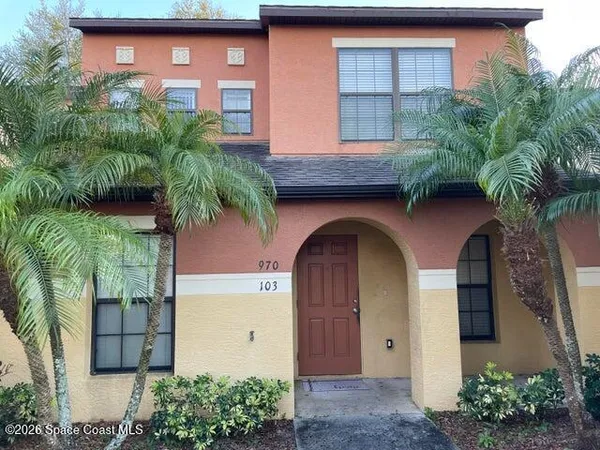 a front view of a house with plants