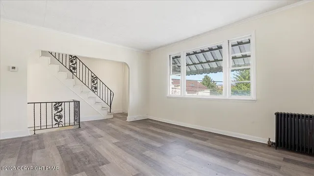 a view of empty room with wooden floor