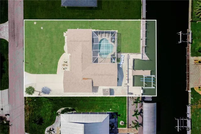 an aerial view of a house with a garden and lake view