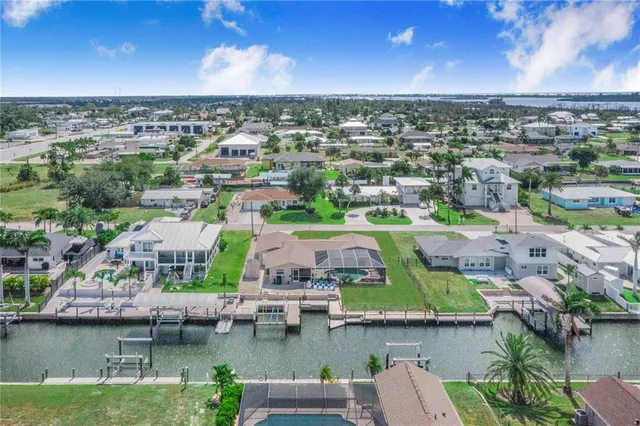 an aerial view of a house with a yard and lake view