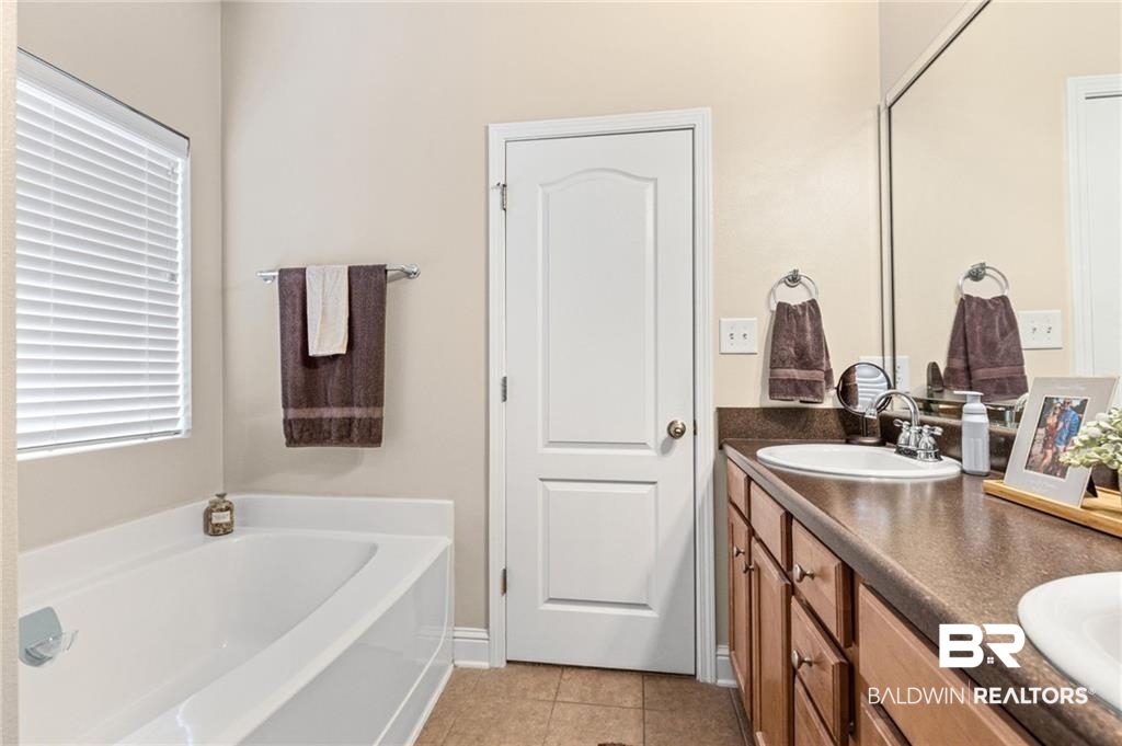 2570 Pecan Pointe Drive Semmes, AL 36575 - Photo 12 of 22 Full bathroom featuring a bath, double vanity, and light tile patterned flooring