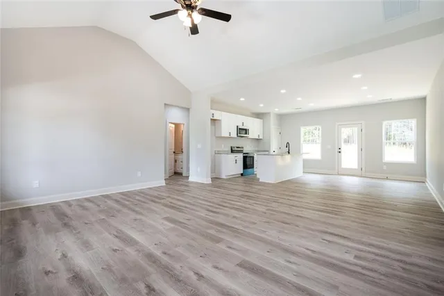 a view of empty room with wooden floor and window