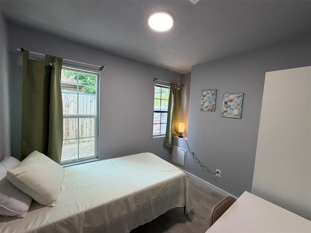 714 Southwest Dallas Street Grand Prairie, TX 75051 - Photo 14 of 27 Compact room featuring grey wall paint and wood-finish flooring