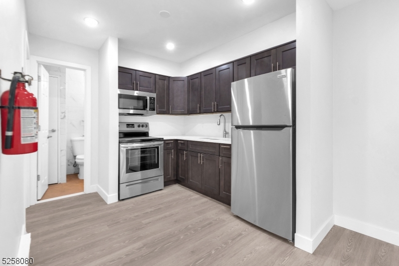 557 South Broad Street, Unit B1 Elizabeth, NJ 07202 - Photo 1 of 6 a kitchen with a refrigerator a stove top oven and cabinets
