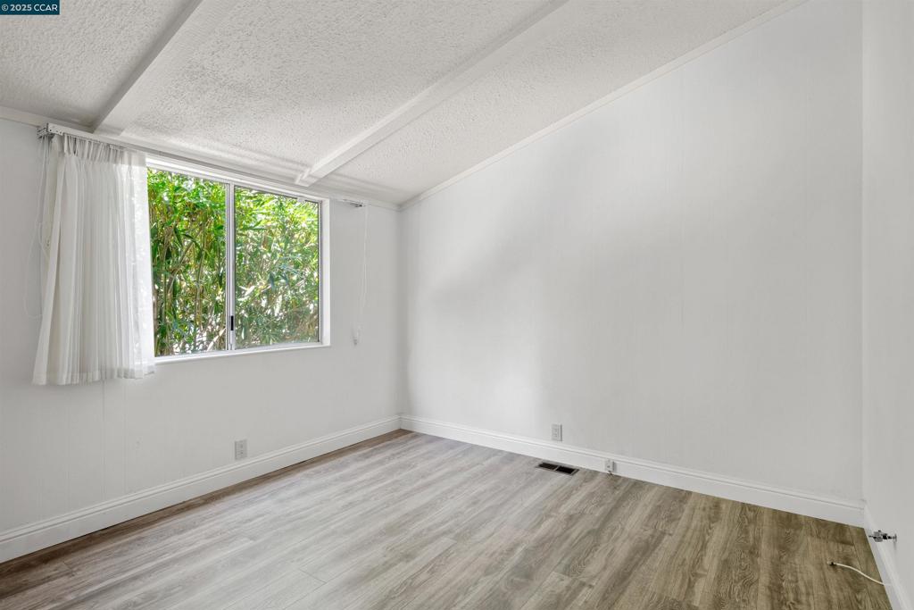 1201 Monument Boulevard Concord, CA 94520 - Photo 18 of 23 an empty room with wooden floor and windows