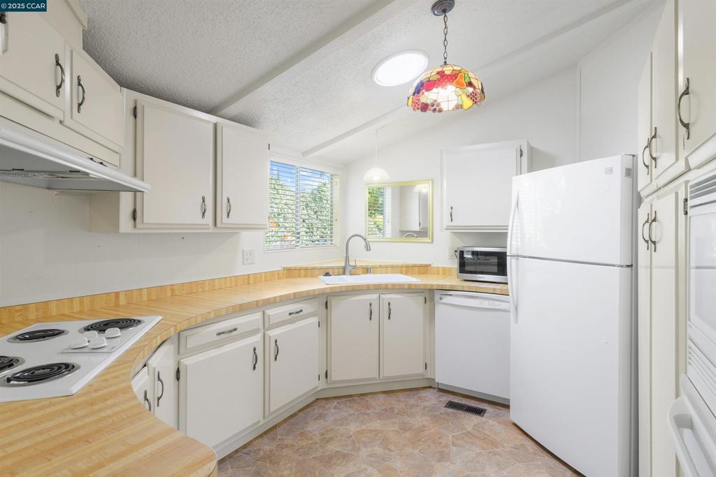 1201 Monument Boulevard Concord, CA 94520 - Photo 9 of 23 a kitchen with white cabinets and white appliances