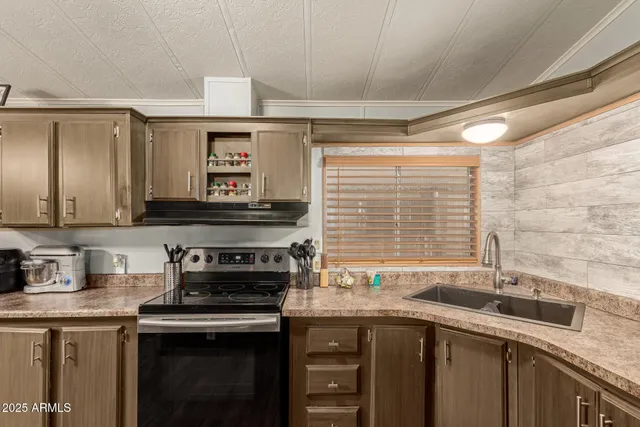 a kitchen with stainless steel appliances granite countertop a sink stove and cabinets