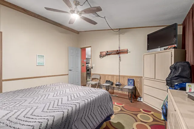 a bedroom with a bed and a flat tv screen on a dresser
