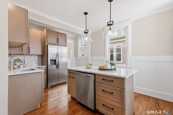 a kitchen with stainless steel appliances a sink stove and refrigerator