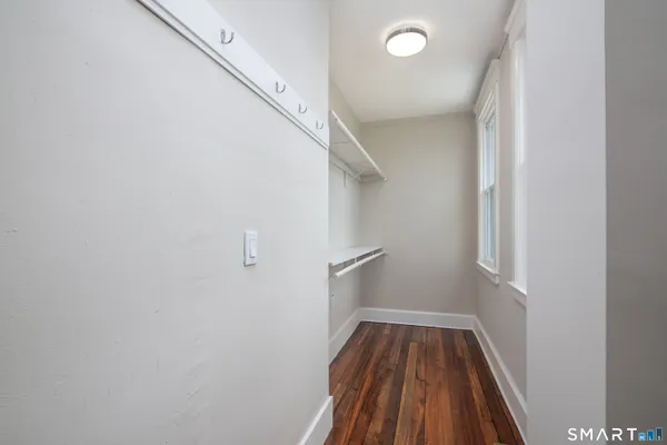 a view of a hallway with wooden floor and staircase