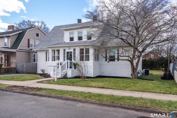 a front view of a house with a yard and trees