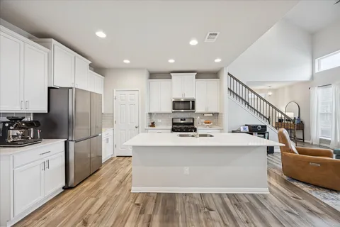 a kitchen with stainless steel appliances a refrigerator a stove top oven a sink dishwasher and a refrigerator