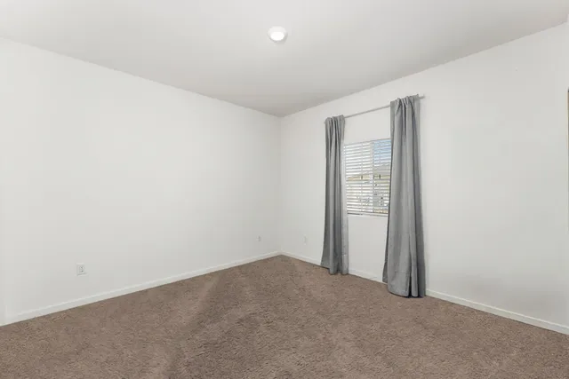 a kitchen with stainless steel appliances a dining table chairs stove refrigerator and cabinets