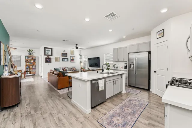 a living room with furniture kitchen view and a flat screen tv