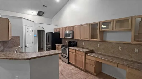 a kitchen with stainless steel appliances granite countertop a sink and a refrigerator