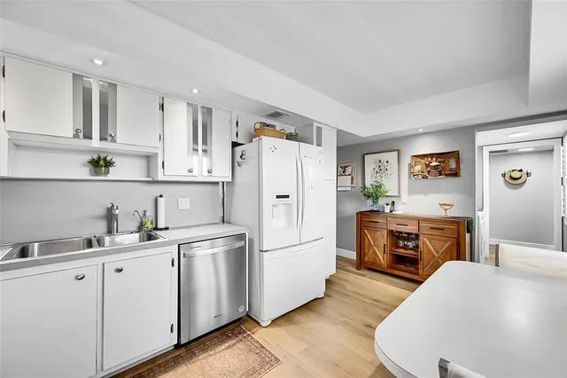 a kitchen with cabinets a sink a refrigerator a stove and wooden floors