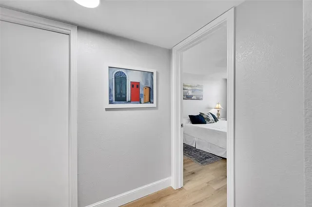 a view of a hallway with wooden floor and closet