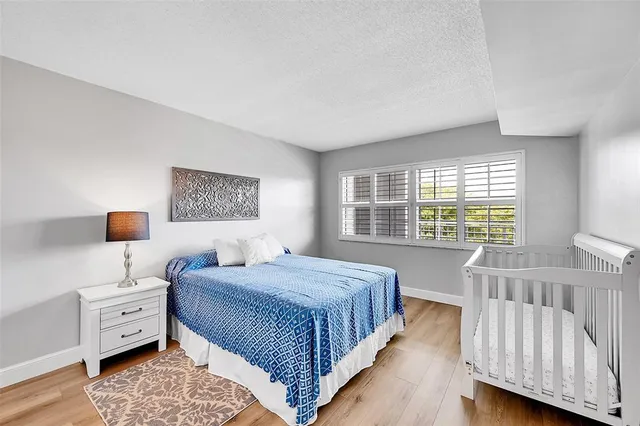 a bedroom with a bed and a lamp with the wooden floor