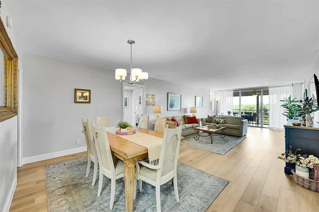 a view of a dining room and livingroom with furniture wooden floor and a chandelier