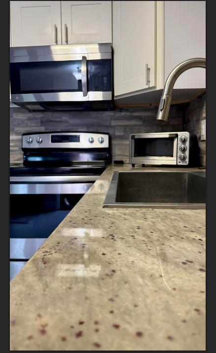 8110 Skillman Street, Unit 2057 Dallas, TX 75231 - Photo 11 of 16 a kitchen with a stove and a microwave