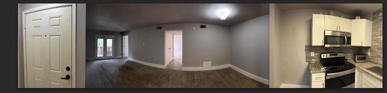 8110 Skillman Street, Unit 2057 Dallas, TX 75231 - Photo 6 of 16 a view of a hallway with wooden floor and a living room