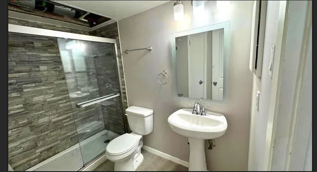 a bathroom with a sink toilet and shower