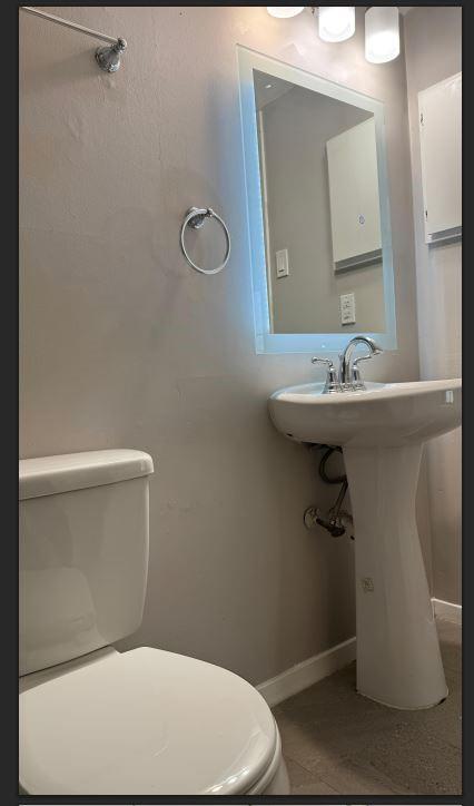 8110 Skillman Street, Unit 2057 Dallas, TX 75231 - Photo 10 of 16 a bathroom with a sink a toilet and mirror