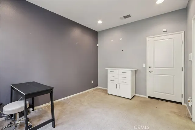 a bedroom with a bed and a lamp on dresser