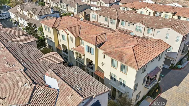 an aerial view of a city with lots of residential buildings and mountain view in back
