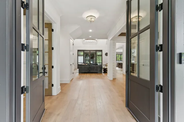 a view of a hallway with wooden floor and a living room