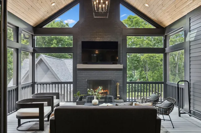 a living room with furniture a fireplace and a floor to ceiling window