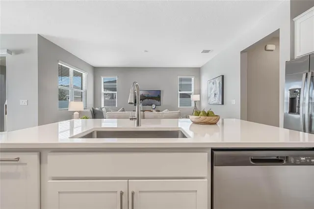 a view with granite countertop a sink white cabinets and a wooden floor