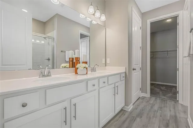 a bathroom with a double vanity sink mirror and shower