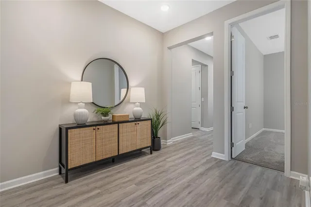 a view of a bathroom with sink mirror and wooden floor