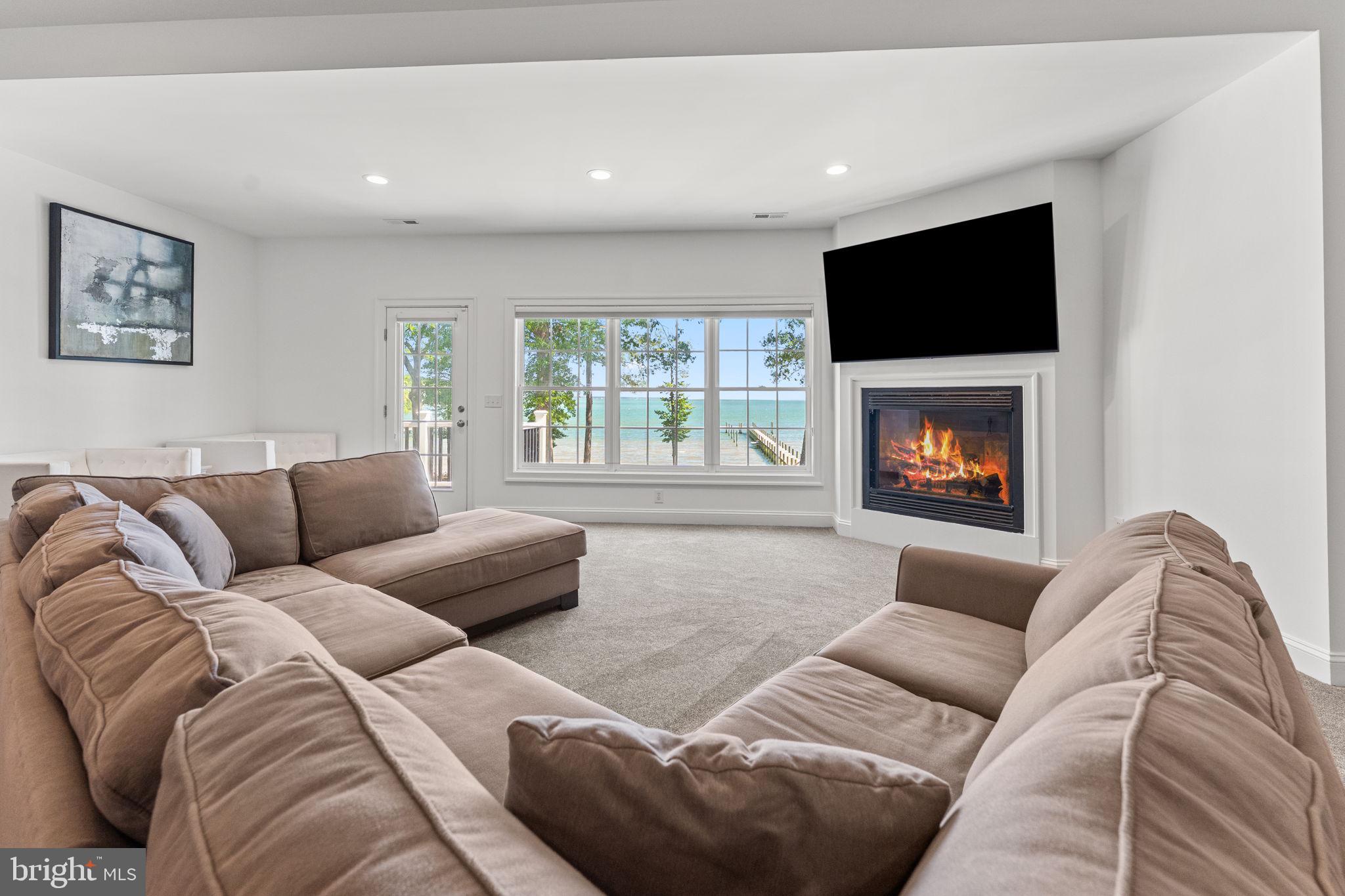 3315 Windmill Point Road White Stone, VA 22578 - Photo 22 of 45 a living room with furniture a flat screen tv and a fireplace