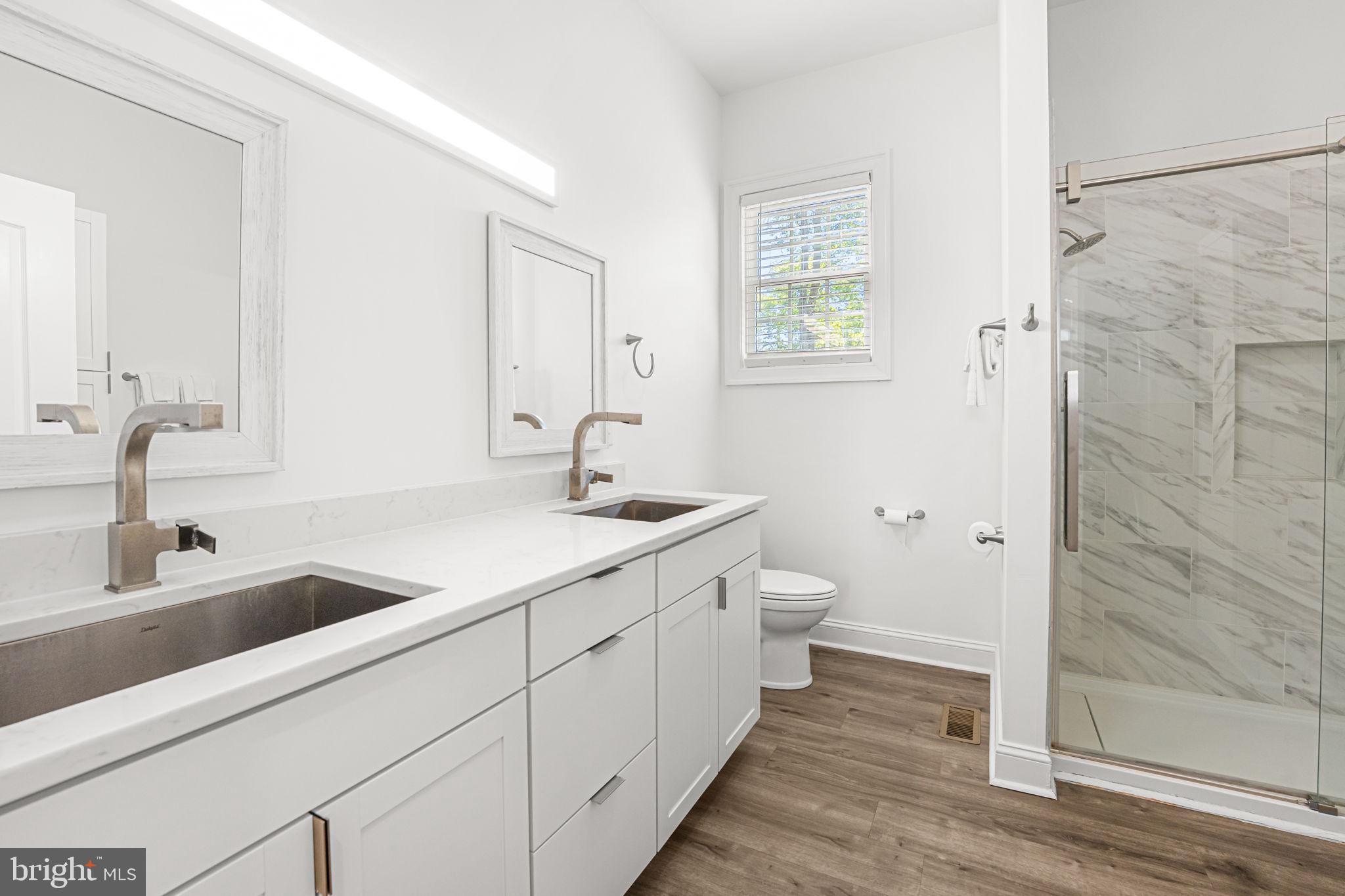 3315 Windmill Point Road White Stone, VA 22578 - Photo 25 of 45 a bathroom with a double vanity sink a toilet and a mirror