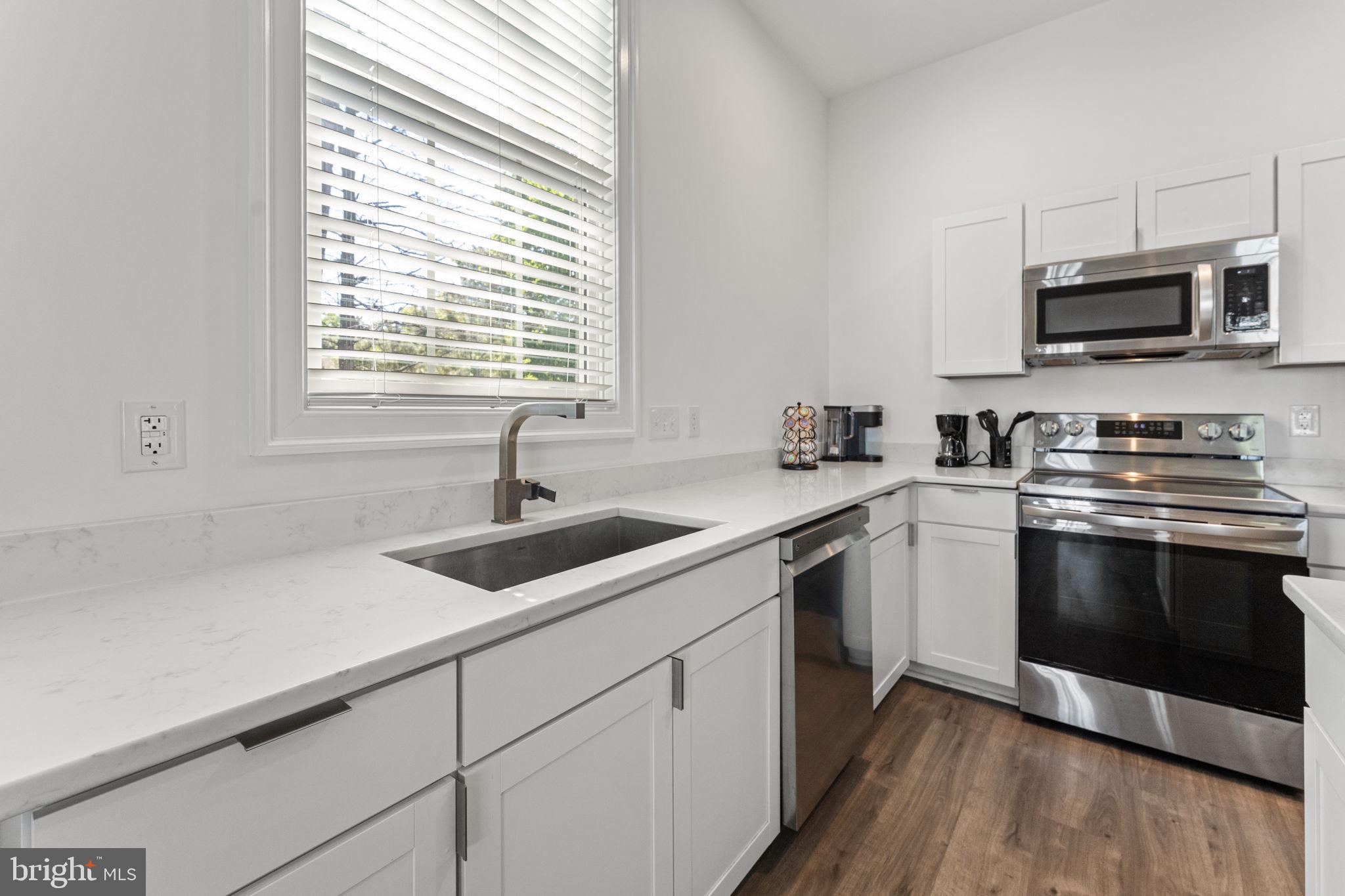 3315 Windmill Point Road White Stone, VA 22578 - Photo 29 of 45 a kitchen with stainless steel appliances white cabinets a sink and a microwave