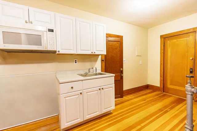 a kitchen with a sink cabinets and wooden floor