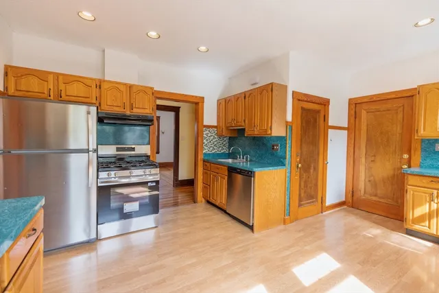 a kitchen with stainless steel appliances a refrigerator and a stove top oven