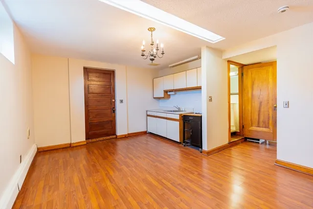 a view of a kitchen with wooden floor and a ceiling fan