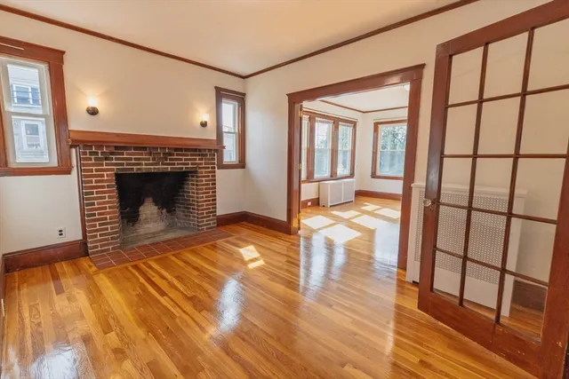 a view of a livingroom with wooden floor and a fireplace
