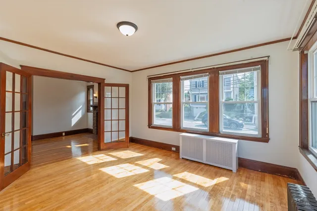 a view of empty room with wooden floor and fan