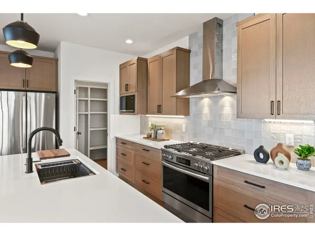 a kitchen with stainless steel appliances kitchen island granite countertop a stove a sink and a refrigerator