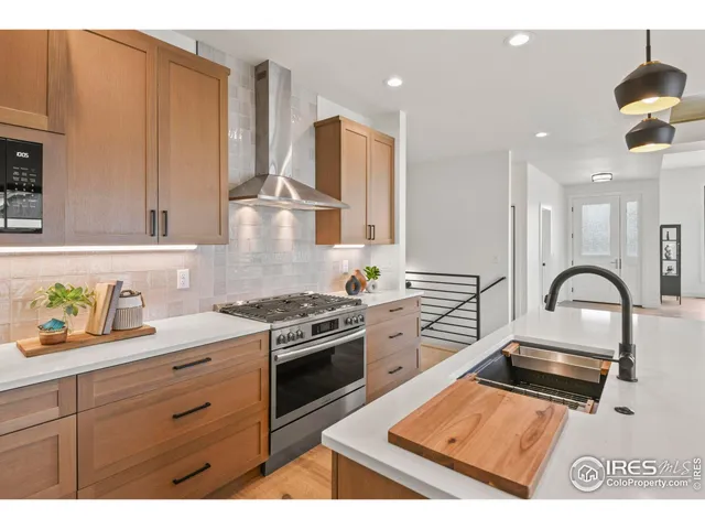a kitchen with stainless steel appliances granite countertop a stove a sink and a microwave