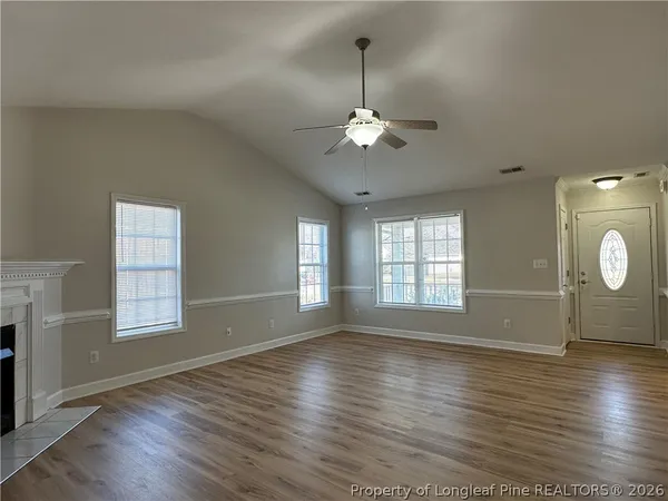 an empty room with wooden floor and windows