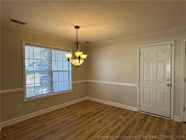a kitchen with stainless steel appliances granite countertop a refrigerator a sink and white cabinets