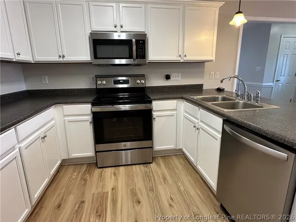 a view of a refrigerator in kitchen with white cabinets