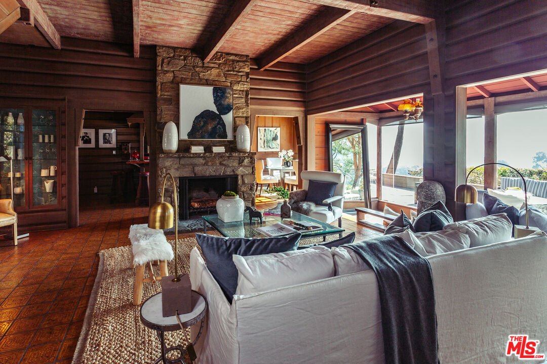2780 Outpost Drive Los Angeles, CA 90068 - Photo 3 of 20 a living room with furniture a fireplace a flat screen tv and floor to ceiling window